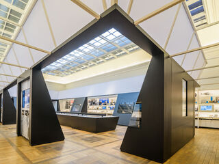 Haus der Weimarer Republik In der Mitte des Raumes steht ein langer Tisch, umgeben von interaktiven Displays und Ausstellungsstücken.