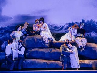 Ariadne auf Naxos im Deutschen Nationaltheater Weimar Eine Gruppe von Schauspielern in historischen Kostümen posiert auf großen Felsen vor einer dramatischen Küstenlandschaft.