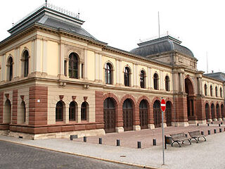 Marstall, heute Thüringisches Hauptstaatsarchiv Ein historisches Gebäude mit einer eleganten Fassade aus Sandstein und großen Fenstern, umgeben von einem gepflasterten Platz.
