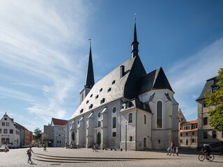 Herderplatz Stadtkirche, Foto: Thomas Müller, weimar GmbH Die Kirche mit ihrem einzigartigen architektonischen Stil zieht die Blicke auf sich, während Passanten und Radfahrer vorbeikommen.
